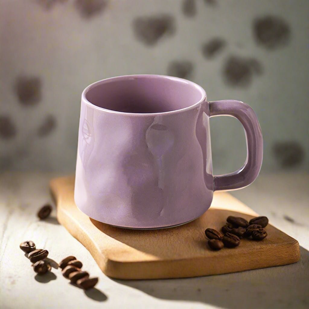 Purple mug on a wooden board with coffee beans against a blurred heart-patterned background