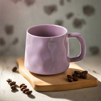 Purple mug on a wooden board with coffee beans against a blurred heart-patterned background