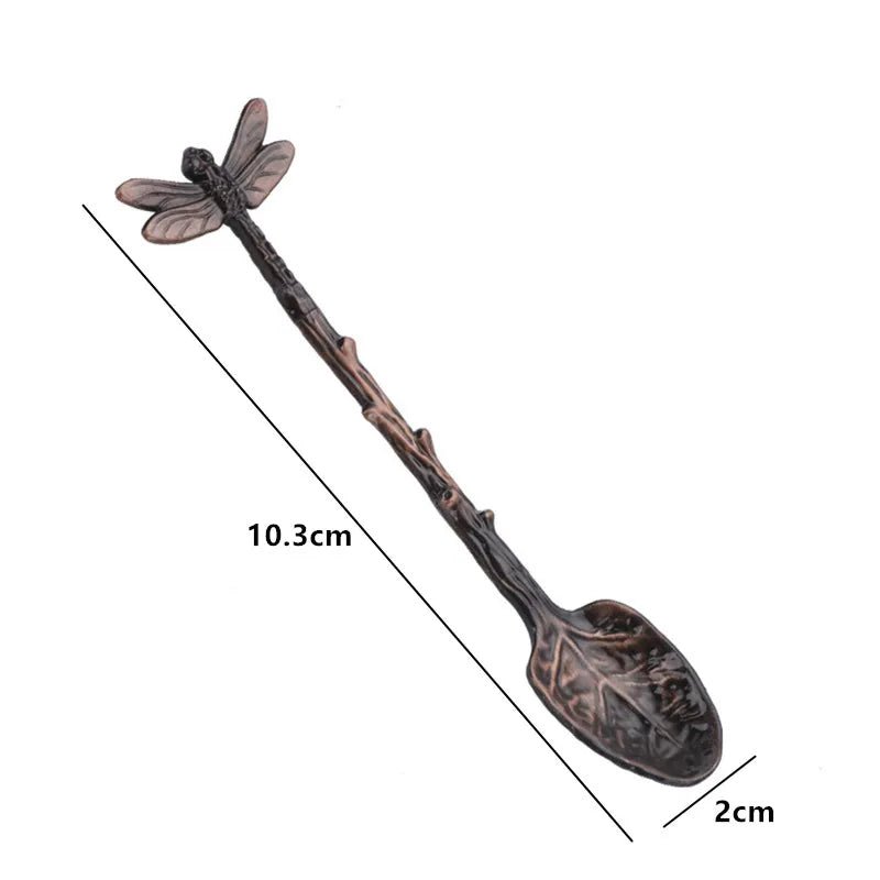 Decorative spoon with dragonfly design and measurements on a white background