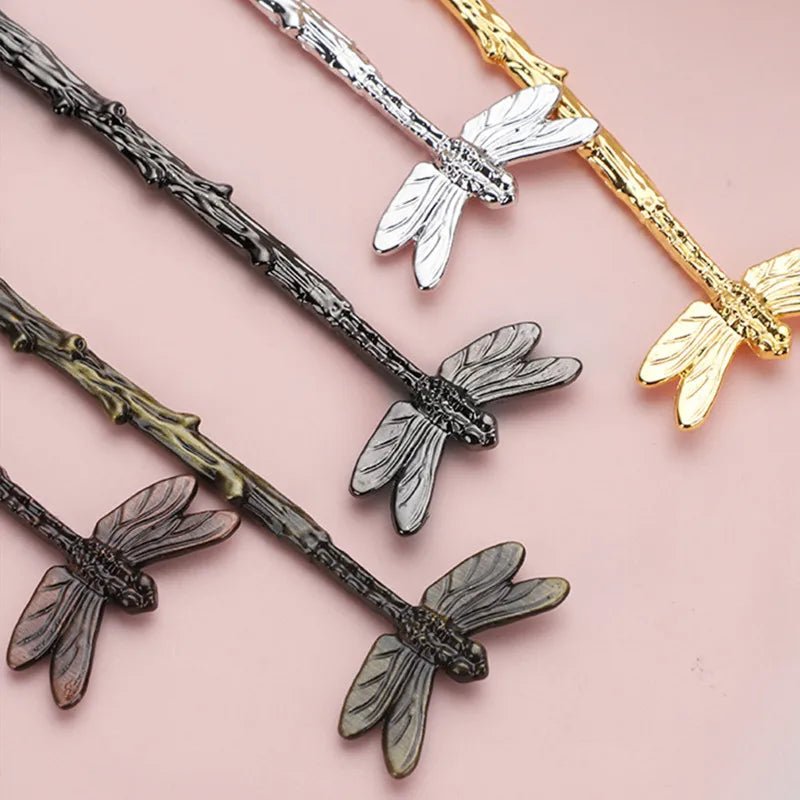 Dragonfly-shaped hairpins in various colors on a pink background