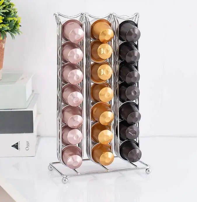 Metallic capsule organizer with pink, gold, and black capsules on a white surface.