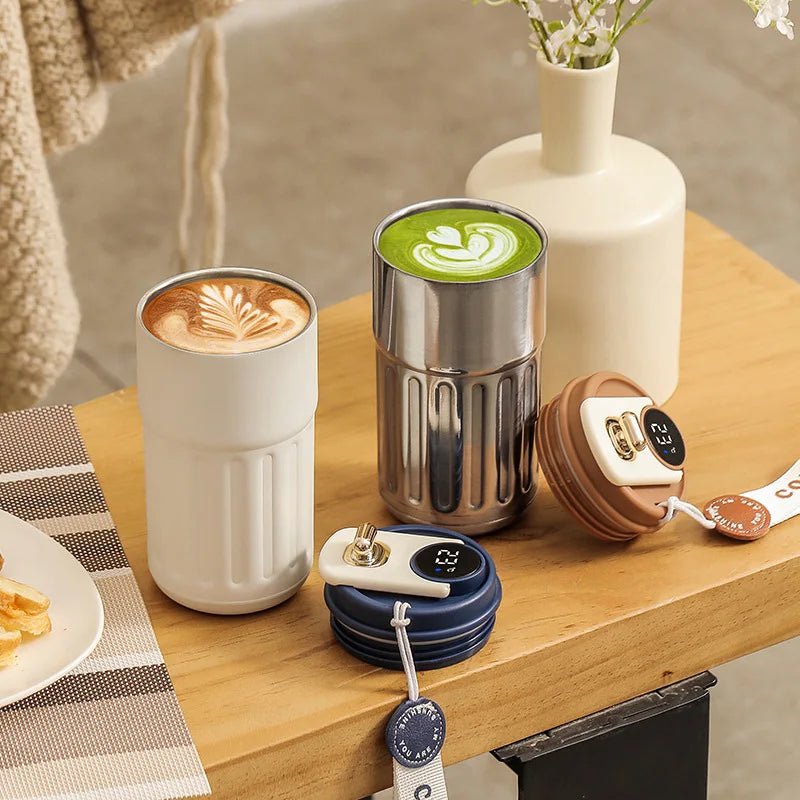 Two tumblers  with different beverages on a wooden table, surrounded by decorative items.