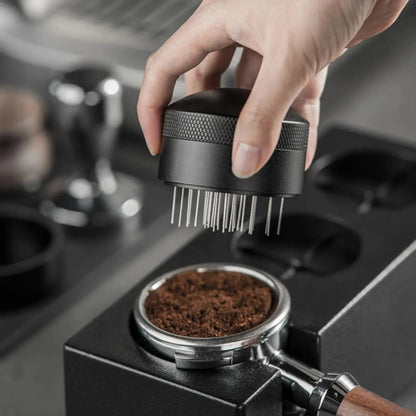 Hand using a coffee grinder to grind coffee beans on a coffee machine.