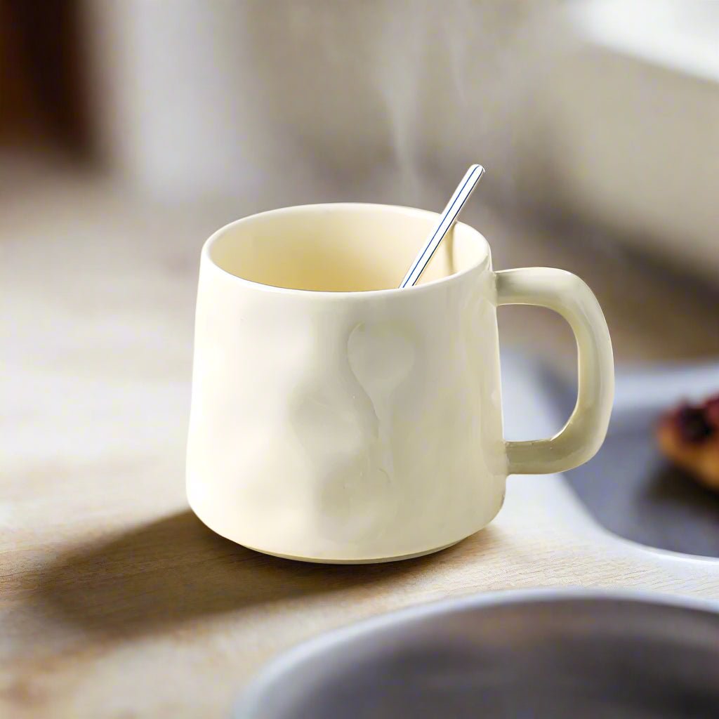 White ceramic mug with a spoon on a wooden surface