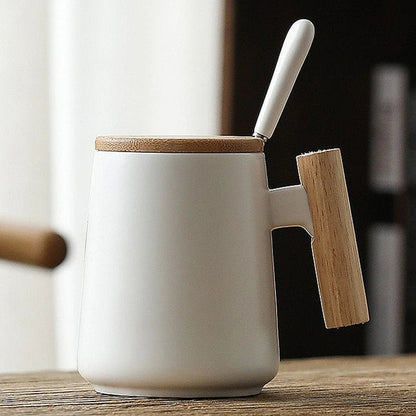 White ceramic mug with wooden lid and handle on a wooden surface